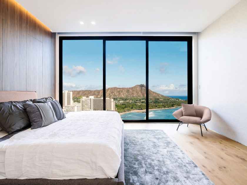 Modern and luxurious hotel bedroom with views of Waikiki beach and skyline in Honolulu, Hawaii. Condo or 5-star upscale accommodation.