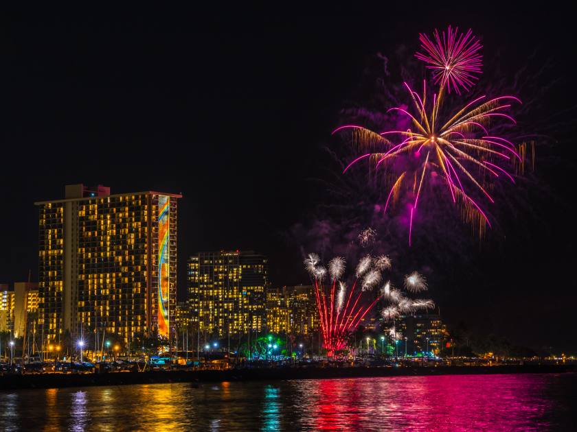 Friday night fireworks show in waikiki hawaii oahu - see lights reflecting in the pacific ocean water
