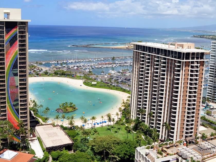 Waikiki beach is known as the world's greatest beach. Surfers ride the waves as vacationers play in the sand.