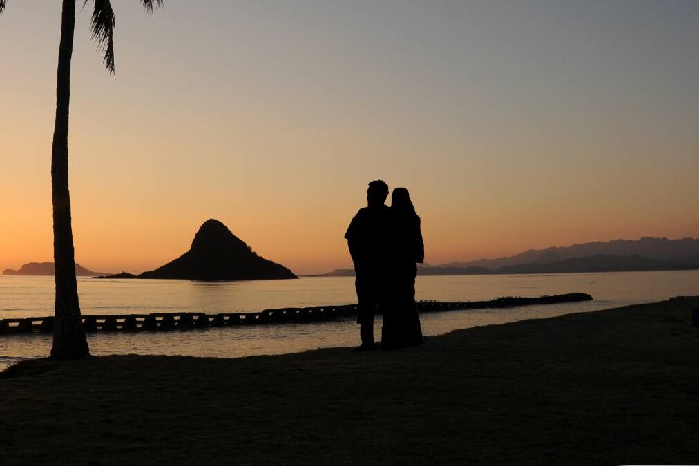 A Couple Enjoying A Chinaman's Hat Sunrise, Oahu, Hawaii