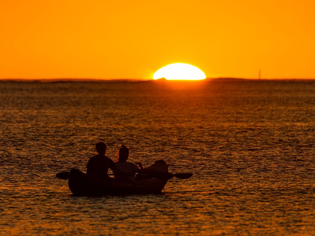Silhouettes,Of,A,Couple,Watching,The,Sun,Setting,Over,A
