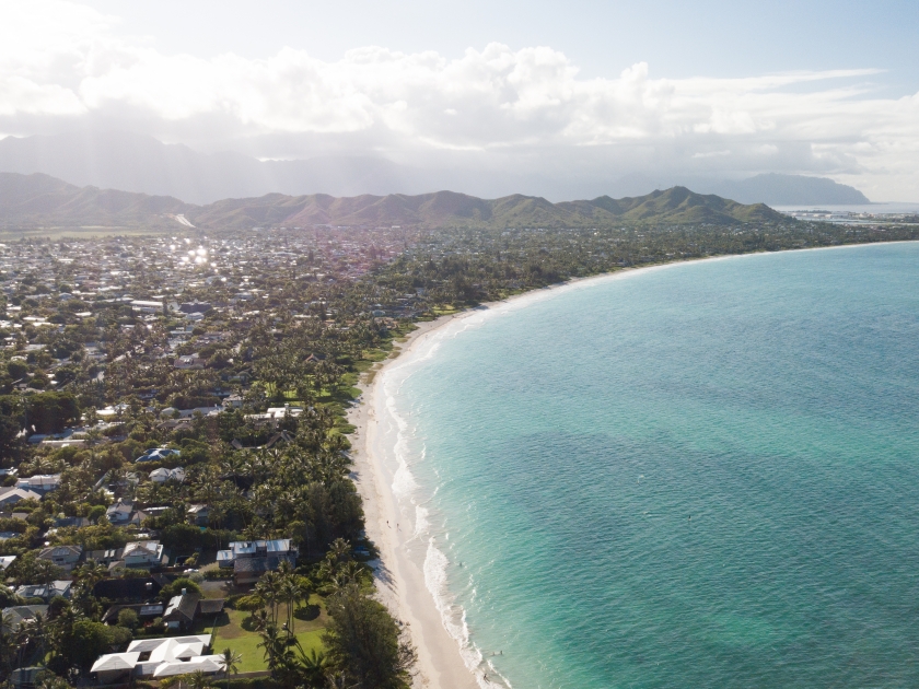 Drone aerial shot of the beautiful Kailua beach shore with tall purple mountains on Oahu Hawaii