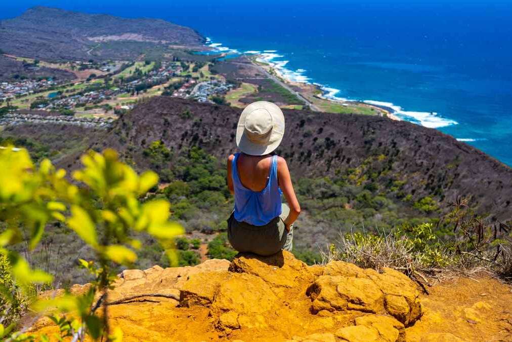 girl in a hat enjoys the oahu panorama from the top of the famous koko crater railway trailhead, oahu, hawaii, hiking in hawaii, holiday in hawaii