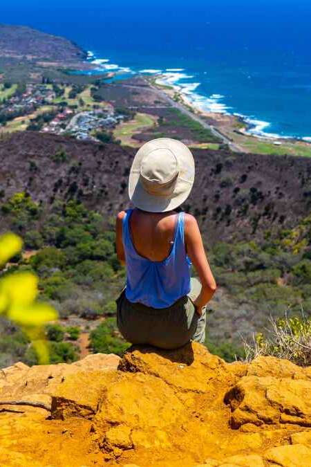 girl in a hat enjoys the oahu panorama from the top of the famous koko crater railway trailhead, oahu, hawaii, hiking in hawaii, holiday in hawaii