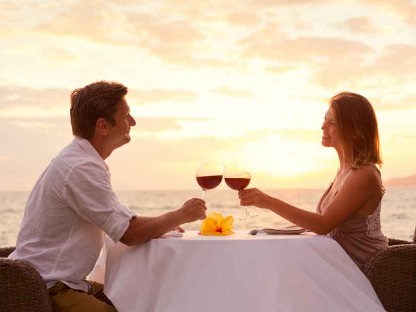 Couple sharing romantic sunset dinner on the beach