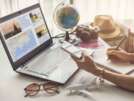 Young woman planning vacation trip and searching information or booking an hotel on a smart phone and laptop, Travel plan concept