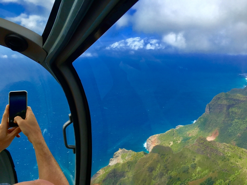 View from helicopter flying over mountain to see ocean view in Kauai Hawaii USA.