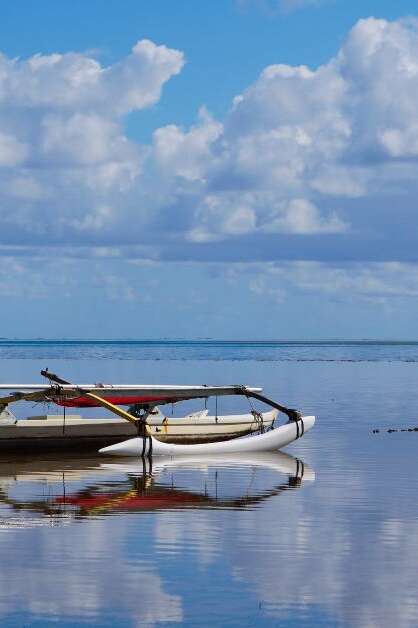 An Outrigger Canoe is Perfectly Mirrored in the Waters of Kaneohe Bay