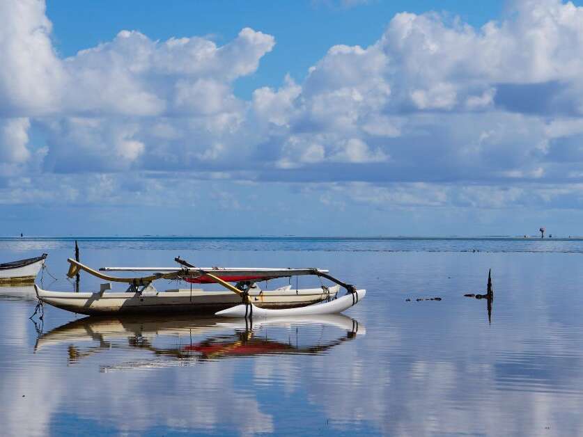 An Outrigger Canoe is Perfectly Mirrored in the Waters of Kaneohe Bay