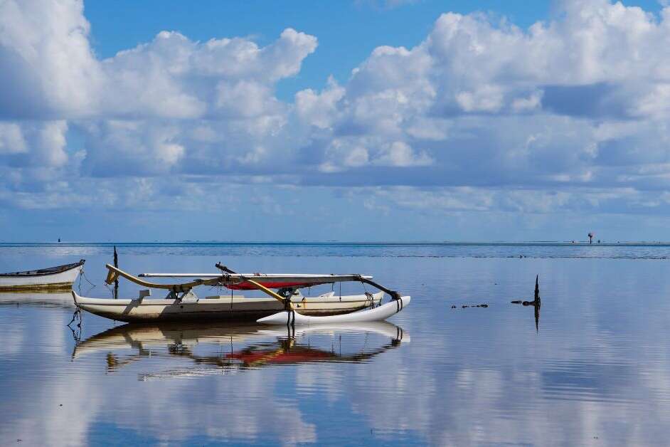 An Outrigger Canoe is Perfectly Mirrored in the Waters of Kaneohe Bay