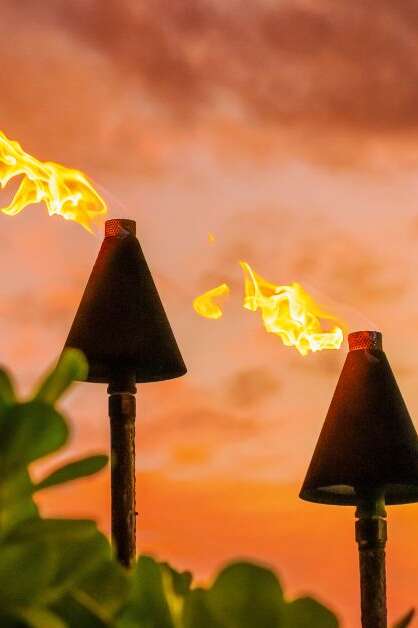 Fire tiki torches against a sunset sky