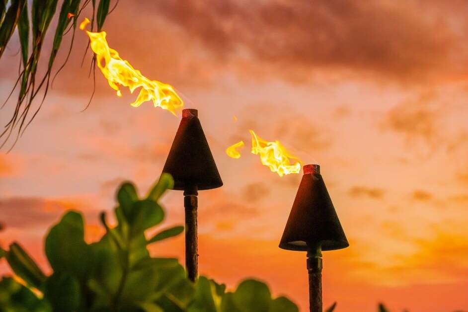 Fire tiki torches against a sunset sky