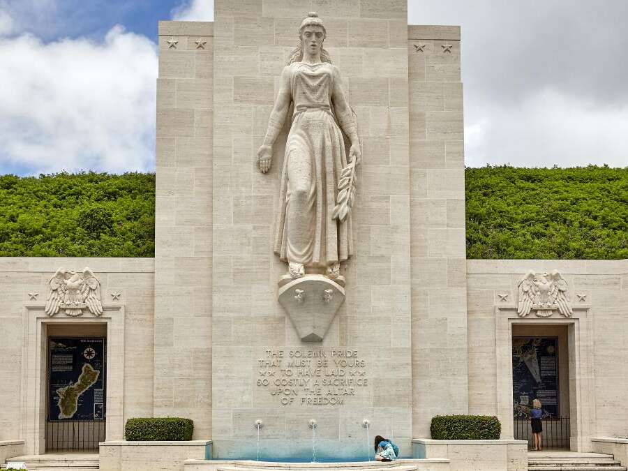 An unidentified woman sits near the fountain monument at National Memorial Cemetery of the Pacific on the island of Oahu, in Hawaii.