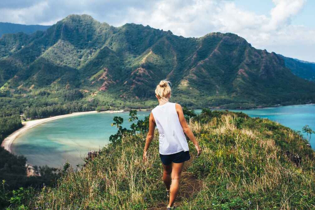 Blonde hiker looks over the ocean on a classic Hawaiian hike.