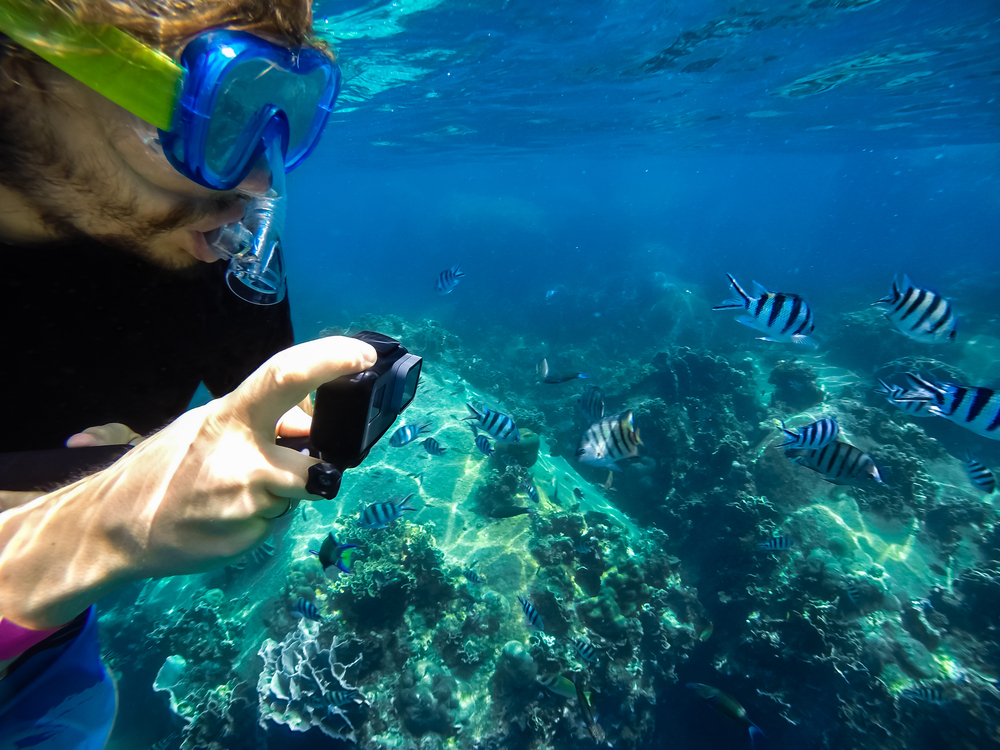 A snorkeler taking picture underwater
