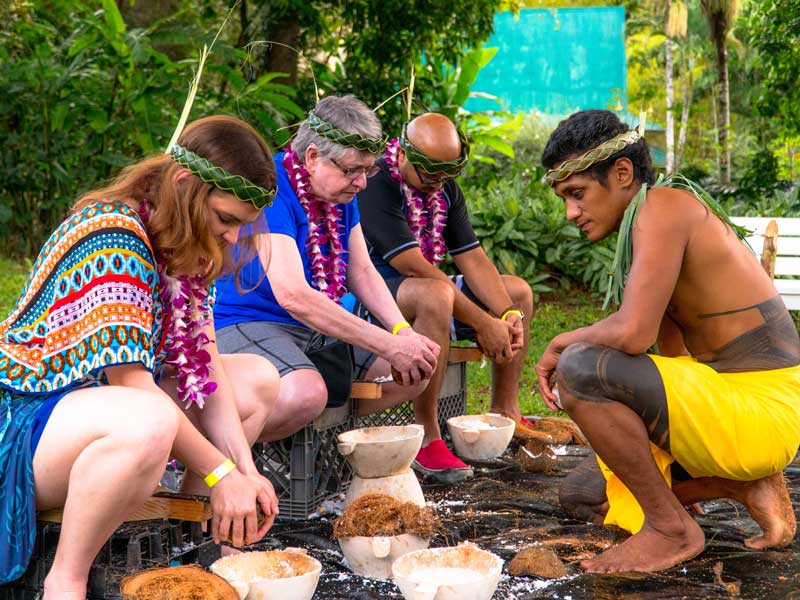 Visitors doing coconut husking as on of Toa Luau activities